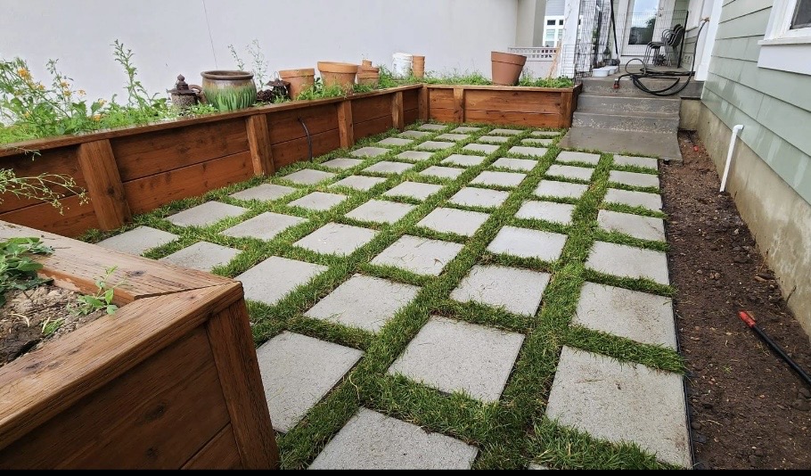 Paver patio with grass joints and raised garden beds